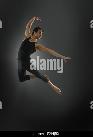 Hispanic ballet dancer leaping in mid-air Stock Photo