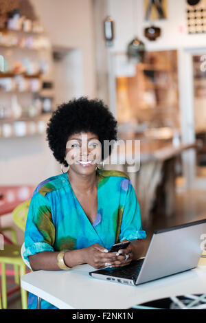 African American business owner using laptop in store Stock Photo