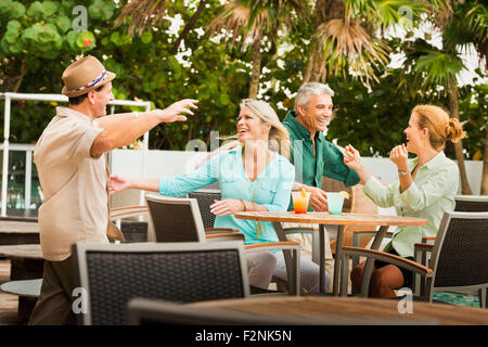 Couples hugging on restaurant patio Stock Photo