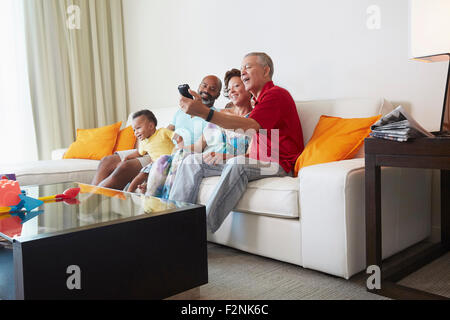 Multi-generation family taking selfie in living room Stock Photo
