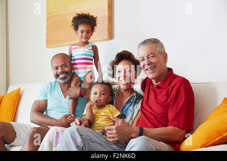 Multi-generation family smiling on sofa Stock Photo