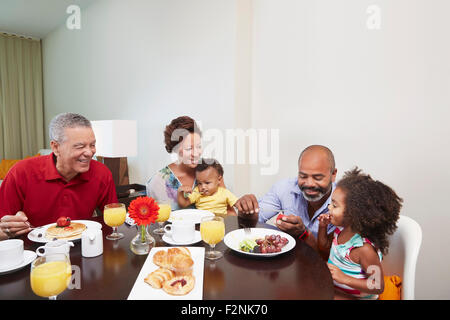 Multi-generation family eating breakfast at table Stock Photo