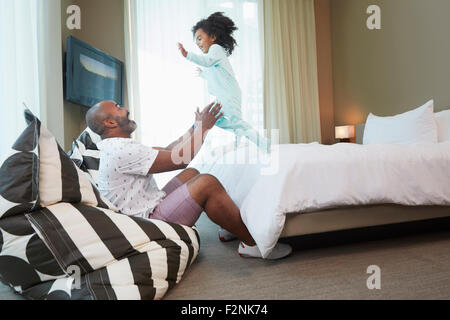 Black father and daughter playing in bedroom Stock Photo