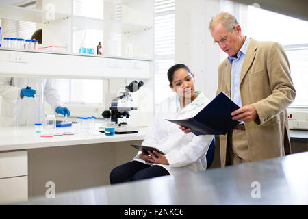 Businessman and scientist talking in laboratory Stock Photo