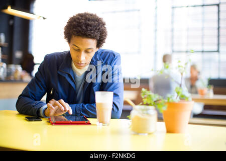 Man using digital tablet in cafe Stock Photo