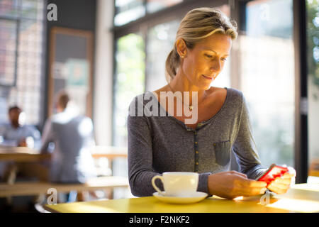 Woman using cell phone in cafe Stock Photo