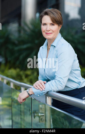 Caucasian businesswoman leaning on banister outdoors Stock Photo