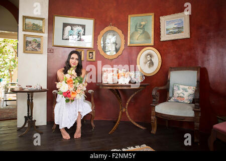 Bride holding bouquet of flowers in waiting room Stock Photo