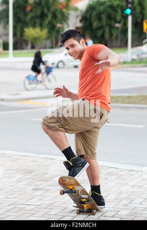 Mixed race man doing trick on skateboard Stock Photo