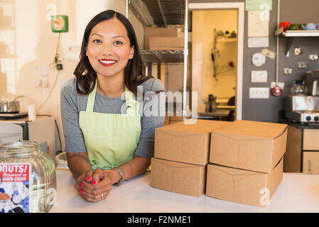 Asian baker smiling in bakery Stock Photo