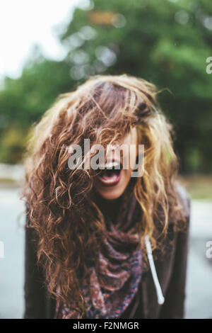Shouting Middle Eastern woman tossing her hair outdoors Stock Photo