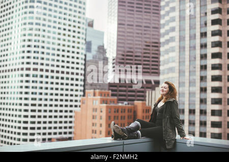 Caucasian woman on urban rooftop admiring cityscape Stock Photo