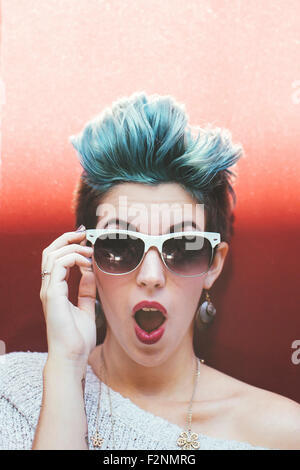 Surprised Caucasian woman with sunglasses and dyed hair Stock Photo