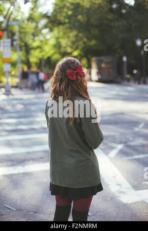 Caucasian woman crossing city intersection Stock Photo