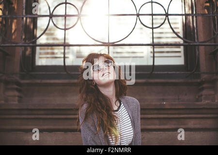 Caucasian woman standing under window Stock Photo