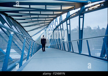 Caucasian businessman walking on sky bridge Stock Photo