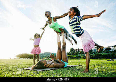 Family practicing acro yoga in park Stock Photo
