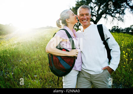 Caucasian couple kissing in tall grass Stock Photo