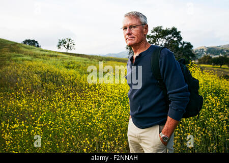 Caucasian man standing in tall grass Stock Photo