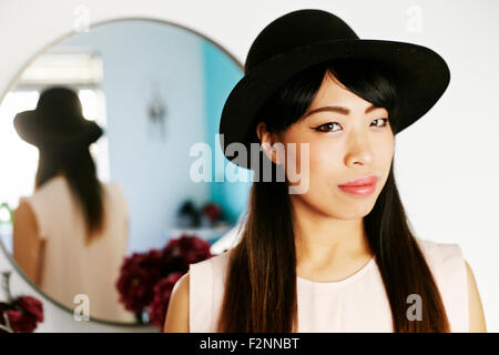 Japanese woman standing at mirror Stock Photo