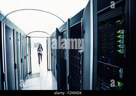 Technician walking in server room Stock Photo