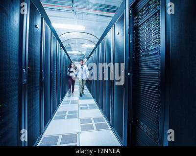 Technicians walking in server room Stock Photo