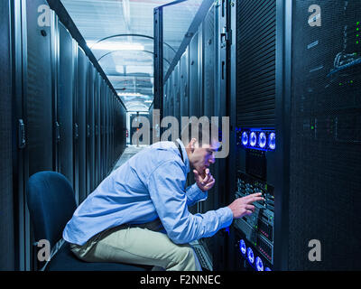 Hispanic technician checking technology in server room Stock Photo
