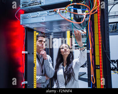 Technicians examining computer in server room Stock Photo