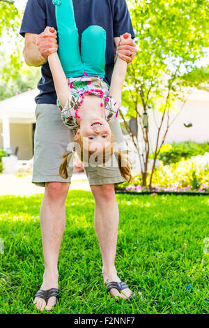 Caucasian father and daughter playing in backyard Stock Photo