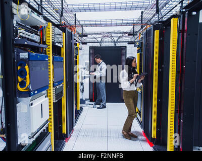 Technicians working in server room Stock Photo