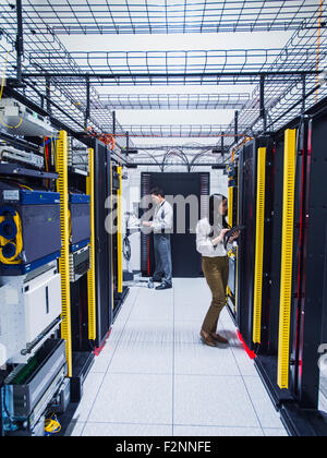 Technicians working in server room Stock Photo