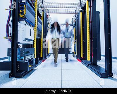 Blurred view of technicians walking in server room Stock Photo
