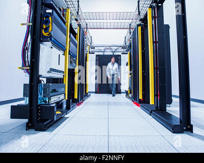 Blurred view of Hispanic technician walking in server room Stock Photo