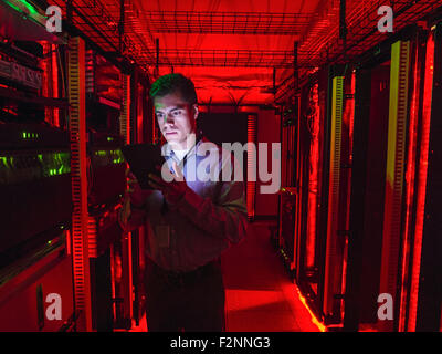 Hispanic technician using digital tablet in server room Stock Photo