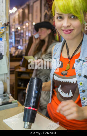 Caucasian artist using heat gun in workshop Stock Photo