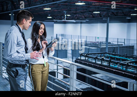 Business people using digital tablet over server room Stock Photo