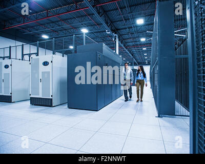 Technicians walking in server room Stock Photo