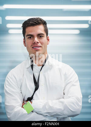 Hispanic businessman standing with arms folded in office Stock Photo