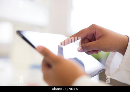 Mixed race scientist using digital tablet in laboratory Stock Photo