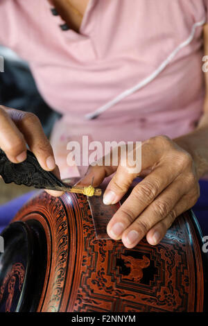 Asian artisan carving traditional design in workshop Stock Photo