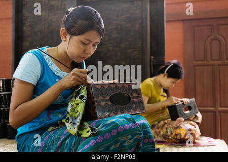 Asian artisans carving traditional design in workshop Stock Photo