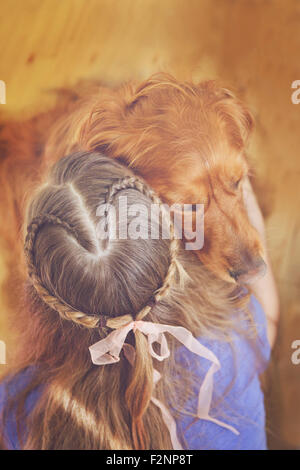 Caucasian girl hugging dog Stock Photo