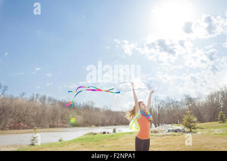 Caucasian girl playing with ribbons in park Stock Photo