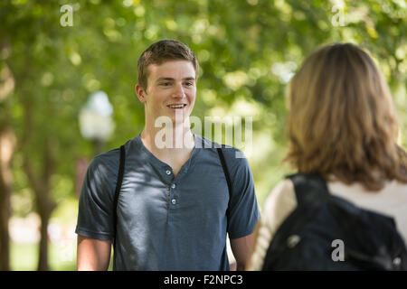 Caucasian students talking on sidewalk Stock Photo