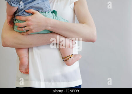 Midsection view of mother holding baby
