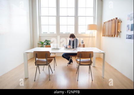 Businesswoman using digital tablet at desk in office Stock Photo