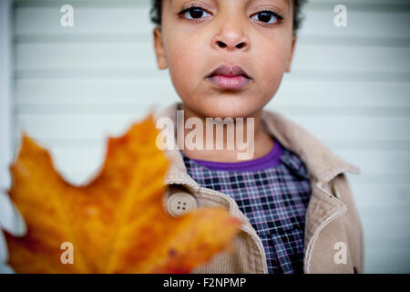 Close up of girl holding autumn leaf Stock Photo