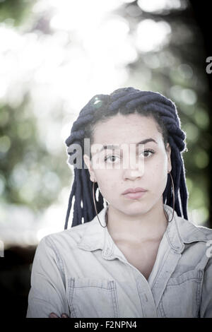 Serious woman with dreadlocks outdoors Stock Photo