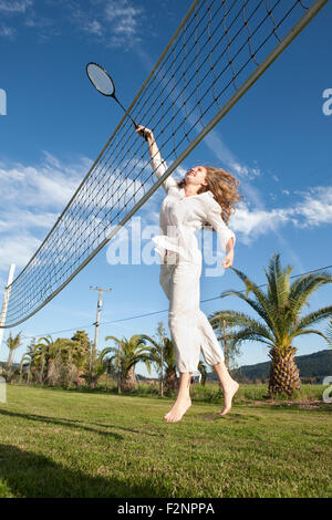 Woman playing badminton in park Stock Photo