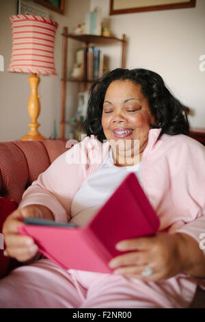 Woman using digital tablet in living room Stock Photo